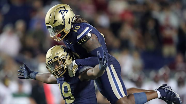 Akron Zips defensive lineman CJ Nunnally IV, bottom, celebrates his strip-sack with linebacker Antavious Fish to seal the win for Akron late in an NCAA college football game against Colgate, Saturday, Sept. 14, 2024, in Akron, Ohio.