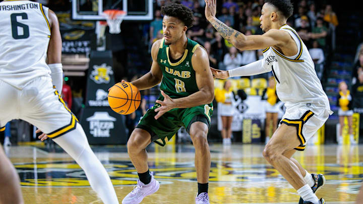 Feb 27, 2025; Wichita, Kansas, USA; UAB Blazers guard Efrem Johnson (8) sets the play around Wichita State Shockers guard Xavier Bell (1) during the first half at Charles Koch Arena. Mandatory Credit: William Purnell-Imagn Images