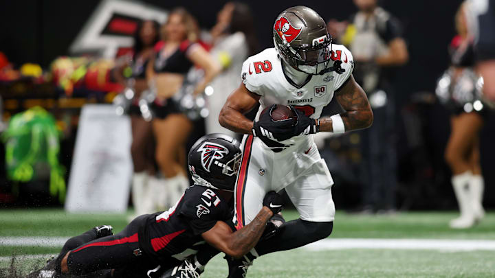 Sep 7, 2025; Atlanta, Georgia, USA; Tampa Bay Buccaneers wide receiver Emeka Egbuka (2) runs with the ball for a touchdown against Atlanta Falcons cornerback Mike Hughes (21) during the second quarter at Mercedes-Benz Stadium.