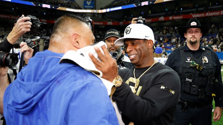 Deion Sanders and Kalani Sitake share congratulations at the end of the Alamo Bowl.