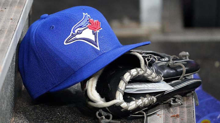 Apr 16, 2025; Toronto, Ontario, CAN; A Toronto Blue Jays hat and glove in the dugout during a game against the Atlanta Braves at Rogers Centre. Mandatory Credit: John E. Sokolowski-Imagn Images