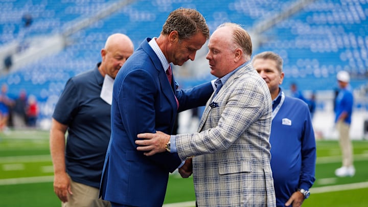Sep 6, 2025; Lexington, Kentucky, USA; Kentucky Wildcats head coach Mark Stoops, right, greets Mississippi Rebels head coach Lane Kiffin before the game at Kroger Field. Mandatory Credit: Jordan Prather-Imagn Images