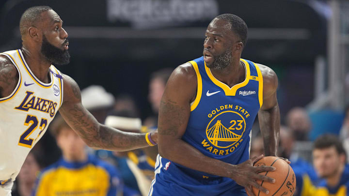 Dec 25, 2024; San Francisco, California, USA; Golden State Warriors forward Draymond Green (right) handles the ball against Los Angeles Lakers forward LeBron James (left) during the first quarter at Chase Center. Mandatory Credit: Darren Yamashita-Imagn Images