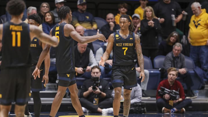 Feb 8, 2025; Morgantown, West Virginia, USA; West Virginia Mountaineers guard Javon Small (7) celebrates with West Virginia Mountaineers guard Toby Okani (5) following a score during the second half against the Utah Utes at WVU Coliseum. Mandatory Credit: Ben Queen-Imagn Images