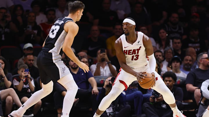 Oct 15, 2024; Miami, Florida, USA; Miami Heat center Bam Adebayo (13) controls the basketball against San Antonio Spurs forward Zach Collins (23) during the second quarter at Kaseya Center. Mandatory Credit: Sam Navarro-Imagn Images