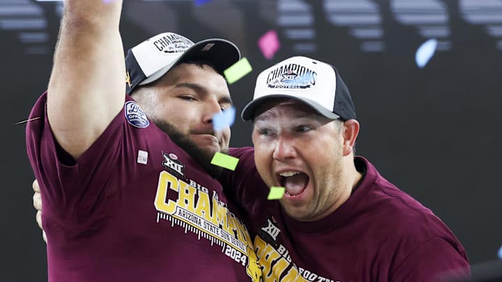 Arizona State Sun Devils running back Cam Skattebo (4) celebrates with Arizona State football coach Kenny Dillingham with the Big 12 Championship trophy.