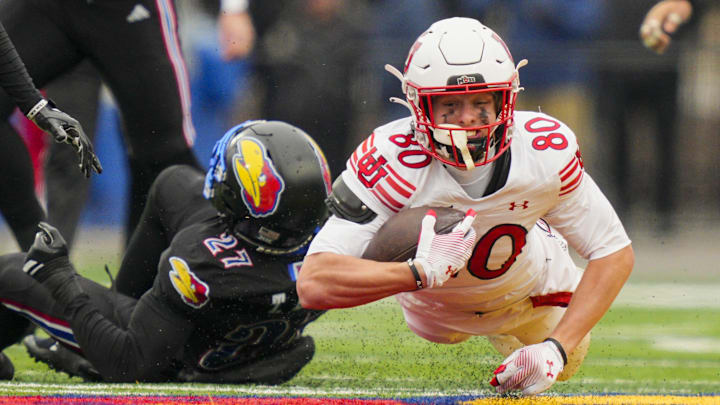 Utah Utes wide receiver Creed Whittemore (80) dives forward during the second half against the Kansas Jayhawks at David Booth Kansas Memorial Stadium.