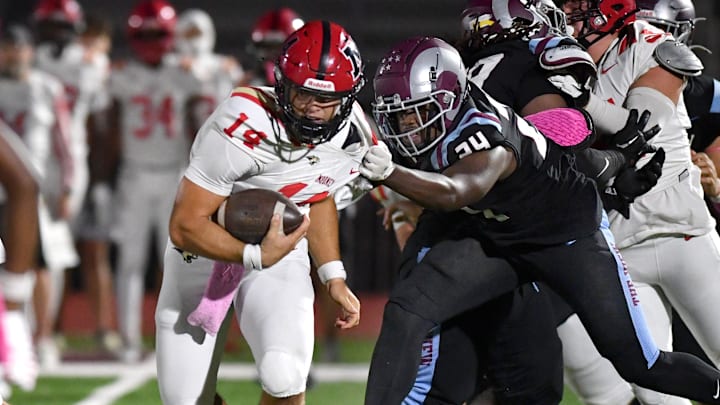 Cardinal Mooney quarterback Devin Mignery (#14) tries to escape the grasp of Riverview linebacker Jamaun Thompson (#24). The Riverview High Rams hosted the Cardinal Mooney Catholic High Cougars Friday evening, Oct. 18, 2024 in Sarasota. Cardinal Mooney quarterback Devin Mignery (#14) tries to escape the grasp of Riverview linebacker Jamaun Thompson (#24). The Riverview High Rams hosted the Cardinal Mooney Catholic High Cougars Friday evening, Oct. 18, 2024 in Sarasota.