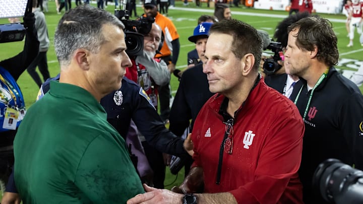 Jan 19, 2026; Miami Gardens, FL, USA; Indiana Hoosiers head coach Curt Cignetti (right) greets Miami Hurricanes head coach Mario Cristobal following the College Football Playoff National Championship game at Hard Rock Stadium. Mandatory Credit: Mark J. Rebilas-Imagn Images