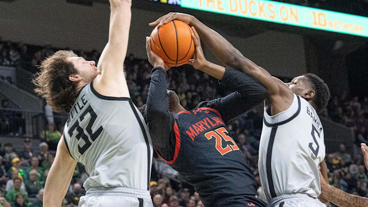Oregon’s Nate Bittle, left, and TJ Bamba, right, force a turnover against Maryland’s Derik Queen during the first half at Matthew Knight Arena.