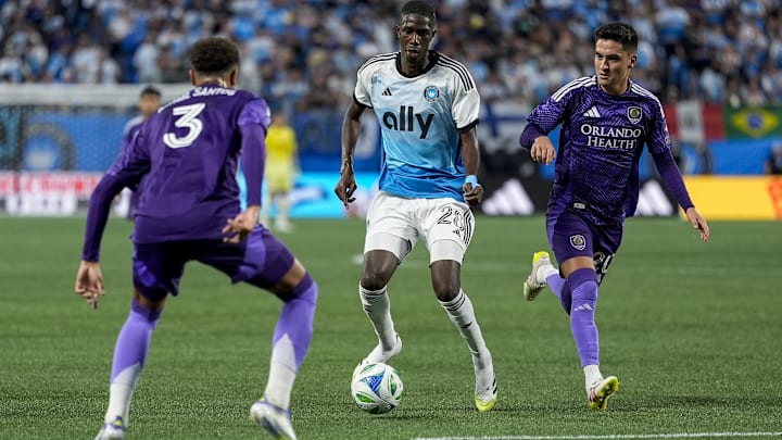 Jul 5, 2025; Charlotte, North Carolina, USA; Charlotte FC defender Adilson Malanda (29) tries to elude Orlando City defender Rafael Santos (3) during the second half at Bank of America Stadium. Mandatory Credit: Jim Dedmon-Imagn Images