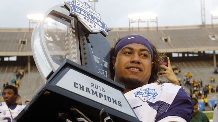 Vita Vea holds the trophy after the Huskies beat Southern Miss 44-31 in the Heart of Dallas Bowl in 2015.