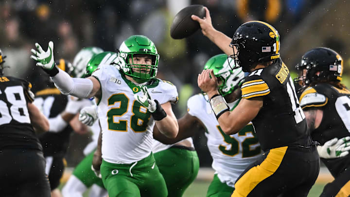 Nov 8, 2025; Iowa City, Iowa, USA; Oregon Ducks linebacker Bryce Boettcher (28) pressures Iowa Hawkeyes quarterback Mark Gronowski (11) during the second quarter at Kinnick Stadium. Mandatory Credit: Jeffrey Becker-Imagn Images