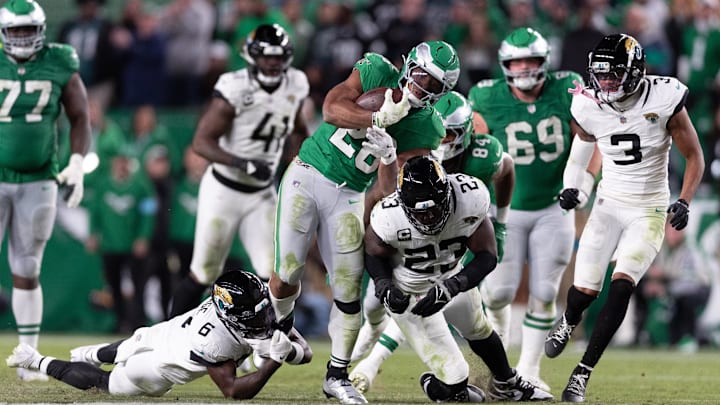 Nov 3, 2024; Philadelphia, Pennsylvania, USA; Philadelphia Eagles running back Saquon Barkley (26) runs with the ball against Jacksonville Jaguars linebacker Foyesade Oluokun (23) and Darnell Savage (6) during the fourth quarter at Lincoln Financial Field. Mandatory Credit: Bill Streicher-Imagn Images