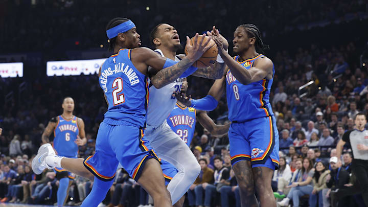 Jan 23, 2025; Oklahoma City, Oklahoma, USA; Dallas Mavericks forward P.J. Washington (25) drives between Oklahoma City Thunder guard Shai Gilgeous-Alexander (2) and forward Jalen Williams (8) during the first quarter at Paycom Center. Mandatory Credit: Alonzo Adams-Imagn Images