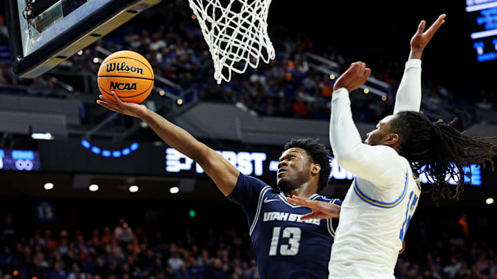 Utah State Aggies guard Deyton Albury (13) shoots the ball against UCLA Bruins guard Sebastian Mack (12). Utah State Aggies guard Deyton Albury (13) shoots the ball against UCLA Bruins guard Sebastian Mack (12).