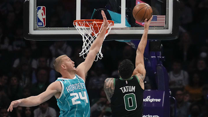 Jan 16, 2023; Charlotte, North Carolina, USA; Boston Celtics forward Jayson Tatum (0) makes a layup guarded by Charlotte Hornets center Mason Plumlee (24) during the second half at Spectrum Center. Mandatory Credit: Jim Dedmon-Imagn Images