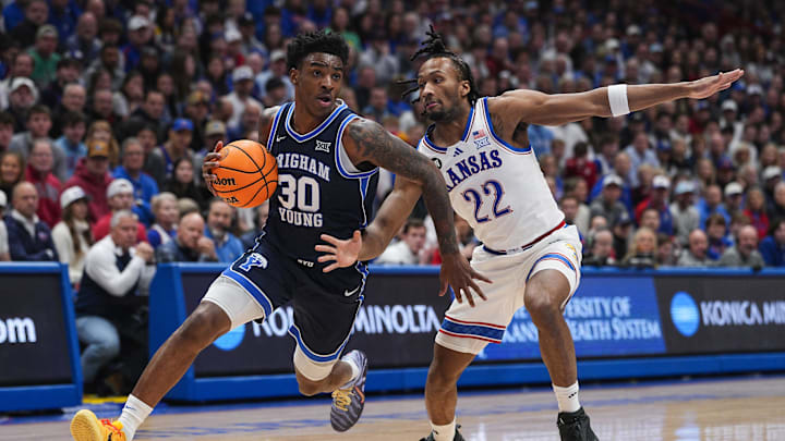 Jan 31, 2026; Lawrence, Kansas, USA; BYU Cougars forward Kennard Davis Jr. (30) drives against Kansas Jayhawks guard Darryn Peterson (22) during the first half at Allen Fieldhouse. Mandatory Credit: Jay Biggerstaff-Imagn Images