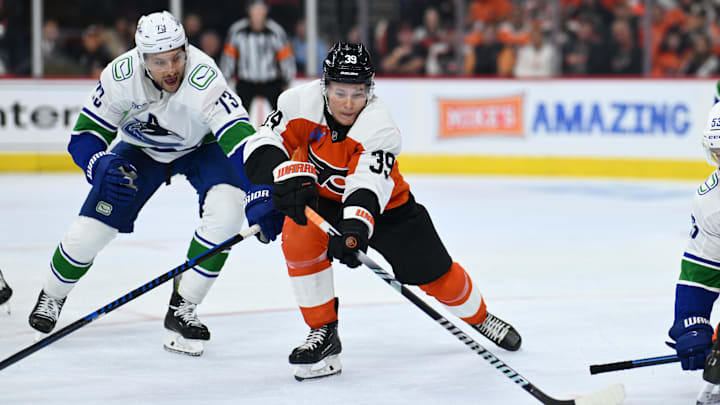 Oct 19, 2024; Philadelphia, Pennsylvania, USA; Philadelphia Flyers right wing Matvei Michkov (39) reaches for the puck against Vancouver Canucks defenseman Vincent Desharnais (73) in the second period at Wells Fargo Center. Mandatory Credit: Kyle Ross-Imagn Images