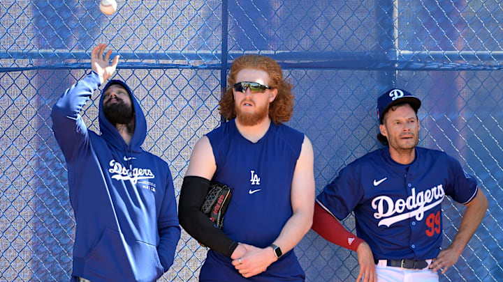 Los Angeles Dodgers starting pitcher Tony Gonsolin (26), starting pitcher Dustin May (85) and relief pitcher Joe Kelly (99) lean on a fence in the bull pen during spring training at Camelback Ranch on Feb. 18, 2024.