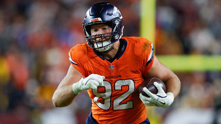 Nov 30, 2025; Landover, Maryland, USA; Denver Broncos tight end Adam Trautman (82) carries the ball after a reception against the Washington Commanders in the second quarter of the game at Northwest Stadium. 