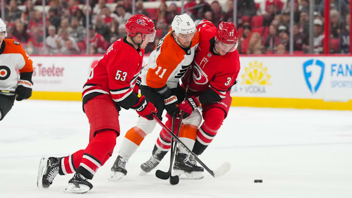 Dec 14, 2025; Raleigh, North Carolina, USA; Carolina Hurricanes right wing Jackson Blake (53) and right wing Andrei Svechnikov (37) battle Philadelphia Flyers right wing Travis Konecny (11) for the puck in the overtime at Lenovo Center. Mandatory Credit: James Guillory-Imagn Images