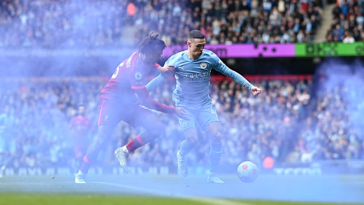 Trent Alexander-Arnold challenges Phil Foden in the smoke of a flare