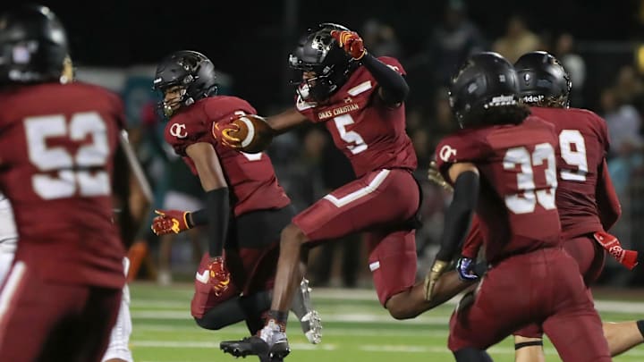 Oaks Christian's Davon Benjamin leaps through an opening after making an interception of a St. Bonaventure pass during the third quarter of the Marmonte League title game on Friday, Oct. 27, 2023, at Oak Christian's Thorson Stadium. Oaks Christian won 13-10.
