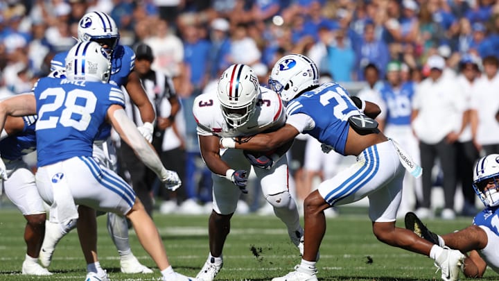 Oct 12, 2024; Provo, Utah, USA; Arizona Wildcats running back Kedrick Reescano (3) is tackled by Brigham Young Cougars cornerback Evan Johnson (21) during the second quarter at LaVell Edwards Stadium. Mandatory Credit: Rob Gray-Imagn Images Oct 12, 2024; Provo, Utah, USA; Arizona Wildcats running back Kedrick Reescano (3) is tackled by Brigham Young Cougars cornerback Evan Johnson (21) during the second quarter at LaVell Edwards Stadium. Mandatory Credit: Rob Gray-Imagn Images