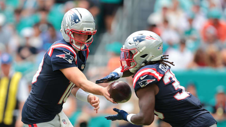 Sep 14, 2025; Miami Gardens, Florida, USA; New England Patriots running back Rhamondre Stevenson (38) takes a handoff from quarterback Drake Maye (10) against the Miami Dolphins during the third quarter at Hard Rock Stadium. Mandatory Credit: Sam Navarro-Imagn Images Sep 14, 2025; Miami Gardens, Florida, USA; New England Patriots running back Rhamondre Stevenson (38) takes a handoff from quarterback Drake Maye (10) against the Miami Dolphins during the third quarter at Hard Rock Stadium. Mandatory Credit: Sam Navarro-Imagn Images