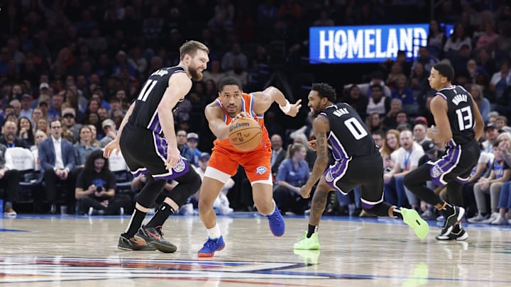 Feb 1, 2025; Oklahoma City, Oklahoma, USA; Oklahoma City Thunder guard Aaron Wiggins (21) drives between Sacramento Kings forward Domantas Sabonis (11) and guard Malik Monk (0) during the second half at Paycom Center. Mandatory Credit: Alonzo Adams-Imagn Images Feb 1, 2025; Oklahoma City, Oklahoma, USA; Oklahoma City Thunder guard Aaron Wiggins (21) drives between Sacramento Kings forward Domantas Sabonis (11) and guard Malik Monk (0) during the second half at Paycom Center. Mandatory Credit: Alonzo Adams-Imagn Images
