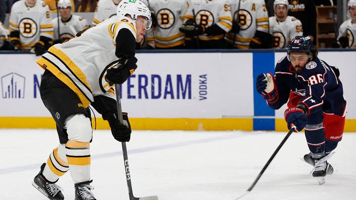Apr 12, 2026; Columbus, Ohio, USA; Boston Bruins defenseman Jordan Harris (43) wrists a shot against Columbus Blue Jackets right wing Kirill Marchenko (86) during the second period at Nationwide Arena. Mandatory Credit: Russell LaBounty-Imagn Images