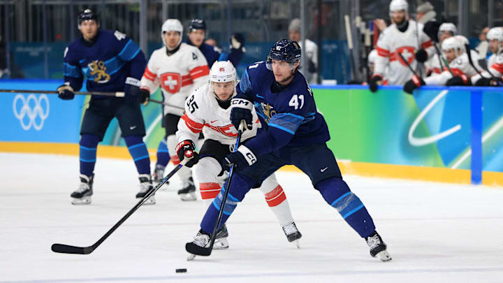 Feb 18, 2026; Milan, Italy; Miro Heiskanen of Finland in action with Sven Andrighetto of Switzerland in a men's ice hockey quarterfinal during the Milano Cortina 2026 Olympic Winter Games at Milano Rho Ice Hockey Arena. Mandatory Credit: Katie Stratman-Imagn Images