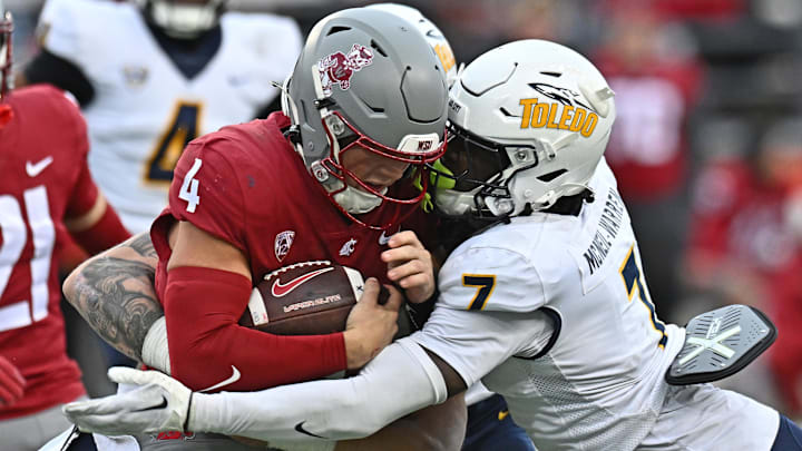 Oct 25, 2025; Pullman, Washington, USA; Washington State Cougars quarterback Zevi Eckhaus (4) is tackled by Toledo Rockets safety Emmanuel McNeil-Warren (7) in the second half at Gesa Field at Martin Stadium. Mandatory Credit: James Snook-Imagn Images