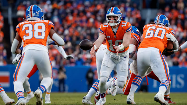 Jan 5, 2025; Denver, Colorado, USA; Denver Broncos quarterback Bo Nix (10) pitches the ball to running back Jaleel McLaughlin (38) as center Luke Wattenberg (60) defends in the third quarter against the Kansas City Chiefs at Empower Field at Mile High. 