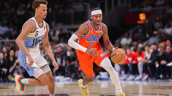 Feb 28, 2025; Atlanta, Georgia, USA; Oklahoma City Thunder guard Shai Gilgeous-Alexander (2) drives past Atlanta Hawks guard Dyson Daniels (5) in the second quarter at State Farm Arena. Mandatory Credit: Brett Davis-Imagn Images