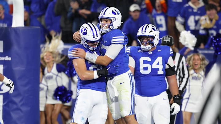 BYU Cougars quarterback Bear Bachmeier (middle) celebrates scoring a touchdown against the Texas Christian University Horned Frogs with tight end Carsen Ryan (20) and offensive lineman Kyle Sfarcioc (64) during the second quarter at LaVell Edwards Stadium. 