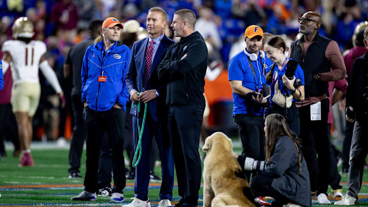 ESPN announcer Kirk Herbstreit talks with Florida Gators head coach Billy Napier while Herbstreit   s dog, Ben, listens during the first half against the Florida State Seminoles at Steve Spurrier Field at Ben Hill Griffin Stadium in Gainesville, FL on Saturday, November 25, 2023. [Matt Pendleton/Gainesville Sun]