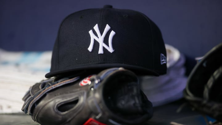 Aug 14, 2023; Atlanta, Georgia, USA; A detailed view of a New York Yankees hat and glove on the bench against the Atlanta Braves in the third inning at Truist Park.