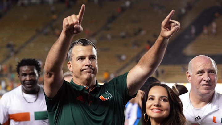 Oct 5, 2024; Berkeley, California, USA; Miami Hurricanes head coach Mario Cristobal (center left) gestures to fans with wife Jessica (center right) after defeating the California Golden Bears at California Memorial Stadium. Mandatory Credit: Darren Yamashita-Imagn Images