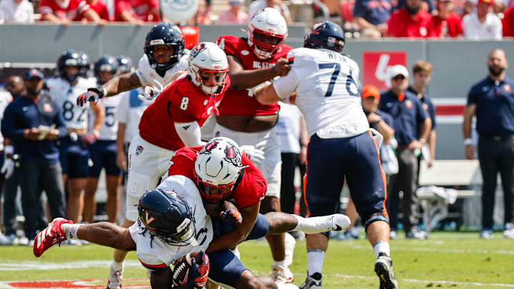 Sep 6, 2025; Raleigh, North Carolina, USA; North Carolina State Wolfpack defensive end Sabastian Harsh (54) tackles Virginia Cavaliers running back J'Mari Taylor (3) during the first half of the game at Carter-Finley Stadium. Mandatory Credit: Jaylynn Nash-Imagn Images Sep 6, 2025; Raleigh, North Carolina, USA; North Carolina State Wolfpack defensive end Sabastian Harsh (54) tackles Virginia Cavaliers running back J'Mari Taylor (3) during the first half of the game at Carter-Finley Stadium. Mandatory Credit: Jaylynn Nash-Imagn Images