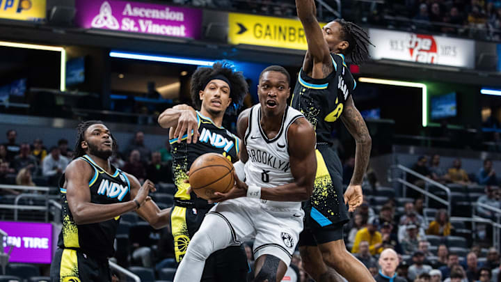 Mar 16, 2024; Indianapolis, Indiana, USA; Brooklyn Nets guard Lonnie Walker IV (8) passes the ball while Indiana Pacers guard Kendall Brown (10) and forward Aaron Nesmith (23) defend in the second half at Gainbridge Fieldhouse. Mandatory Credit: Trevor Ruszkowski-Imagn Images