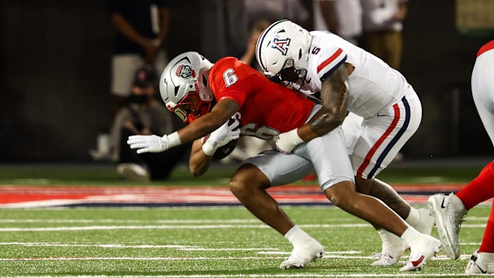 Aug 31, 2024; Tucson, Arizona, USA; New Mexico Lobos running back Eli Sanders (6) get tackled by Arizona Wildcats linebacker Jacob Manu (5) during first quarter at Arizona Stadium. 