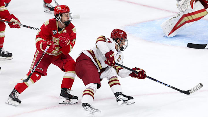 Apr 13, 2024; Saint Paul, Minnesota, USA; Boston College Eagles forward Gabe Perreault (34) skates with the puck as Denver Pioneers defenseman Sean Behrens (2) defends during the first period of the championship game of the 2024 Frozen Four college ice hockey tournament at Xcel Energy Center. Mandatory Credit: Matt Krohn-Imagn Images