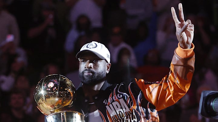Feb 3, 2026; Miami, Florida, USA; Former Miami Heat guard Dwayne Wade holds the Larry O' Brien trophy during a ceremony to honor 20 years since they won their first NBA Championship during halftime at Kaseya Center. Mandatory Credit: Rhona Wise-Imagn Images Feb 3, 2026; Miami, Florida, USA; Former Miami Heat guard Dwayne Wade holds the Larry O' Brien trophy during a ceremony to honor 20 years since they won their first NBA Championship during halftime at Kaseya Center. Mandatory Credit: Rhona Wise-Imagn Images