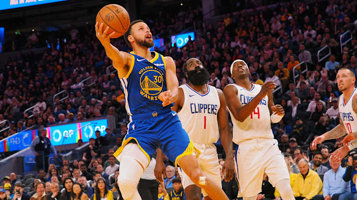 Golden State Warriors guard Stephen Curry (30) scores against Los Angeles Clippers guard James Harden (1), guard Terance Mann (14) during the fourth quarter at Chase Center. Mandatory Credit: Kelley L Cox-Imagn Images