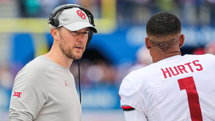Oct 5, 2019; Lawrence, KS, USA; Oklahoma Sooners head coach Lincoln Riley talks with quarterback Jalen Hurts (1) during the first half against the Kansas Jayhawks at David Booth Kansas Memorial Stadium. Mandatory Credit: Jay Biggerstaff-Imagn Images Oct 5, 2019; Lawrence, KS, USA; Oklahoma Sooners head coach Lincoln Riley talks with quarterback Jalen Hurts (1) during the first half against the Kansas Jayhawks at David Booth Kansas Memorial Stadium. Mandatory Credit: Jay Biggerstaff-Imagn Images