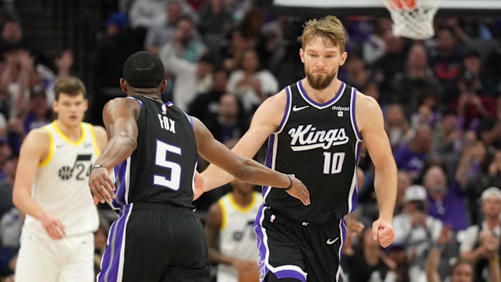 Mar 31, 2024; Sacramento, California, USA; Sacramento Kings guard De'Aaron Fox (5) is congratulated by forward Domantas Sabonis (10) after scoring during the third quarter against the Utah Jazz at Golden 1 Center. Mandatory Credit: Darren Yamashita-USA TODAY Sports