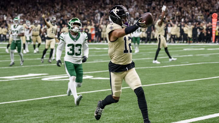 Dec 21, 2025; New Orleans, Louisiana, USA; New Orleans Saints wide receiver Chris Olave (12) crosses the goal line for a touchdown against New York Jets cornerback Jordan Clark (33) during the third quarter at Caesars Superdome. Mandatory Credit: Matthew Hinton-Imagn Images Dec 21, 2025; New Orleans, Louisiana, USA; New Orleans Saints wide receiver Chris Olave (12) crosses the goal line for a touchdown against New York Jets cornerback Jordan Clark (33) during the third quarter at Caesars Superdome. Mandatory Credit: Matthew Hinton-Imagn Images