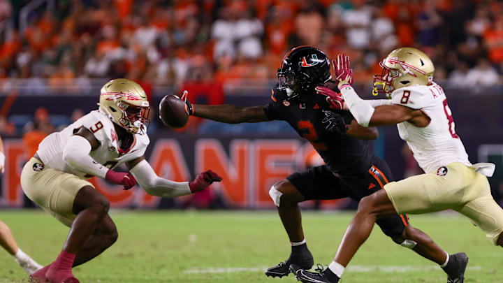 Oct 26, 2024; Miami Gardens, Florida, USA; Miami Hurricanes wide receiver Isaiah Horton (2) attempts but cannot catch the football against Florida State Seminoles defensive back Azareye'h Thomas (8) and linebacker Omar Graham Jr. (9) during the fourth quarter at Hard Rock Stadium. Mandatory Credit: Sam Navarro-Imagn Images